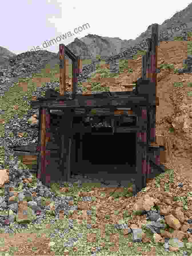 An Abandoned Mine Entrance, Surrounded By Crumbling Rock And Overgrown Vegetation, Whispers Tales Of A Bygone Era Mines Of The Alpine Loop